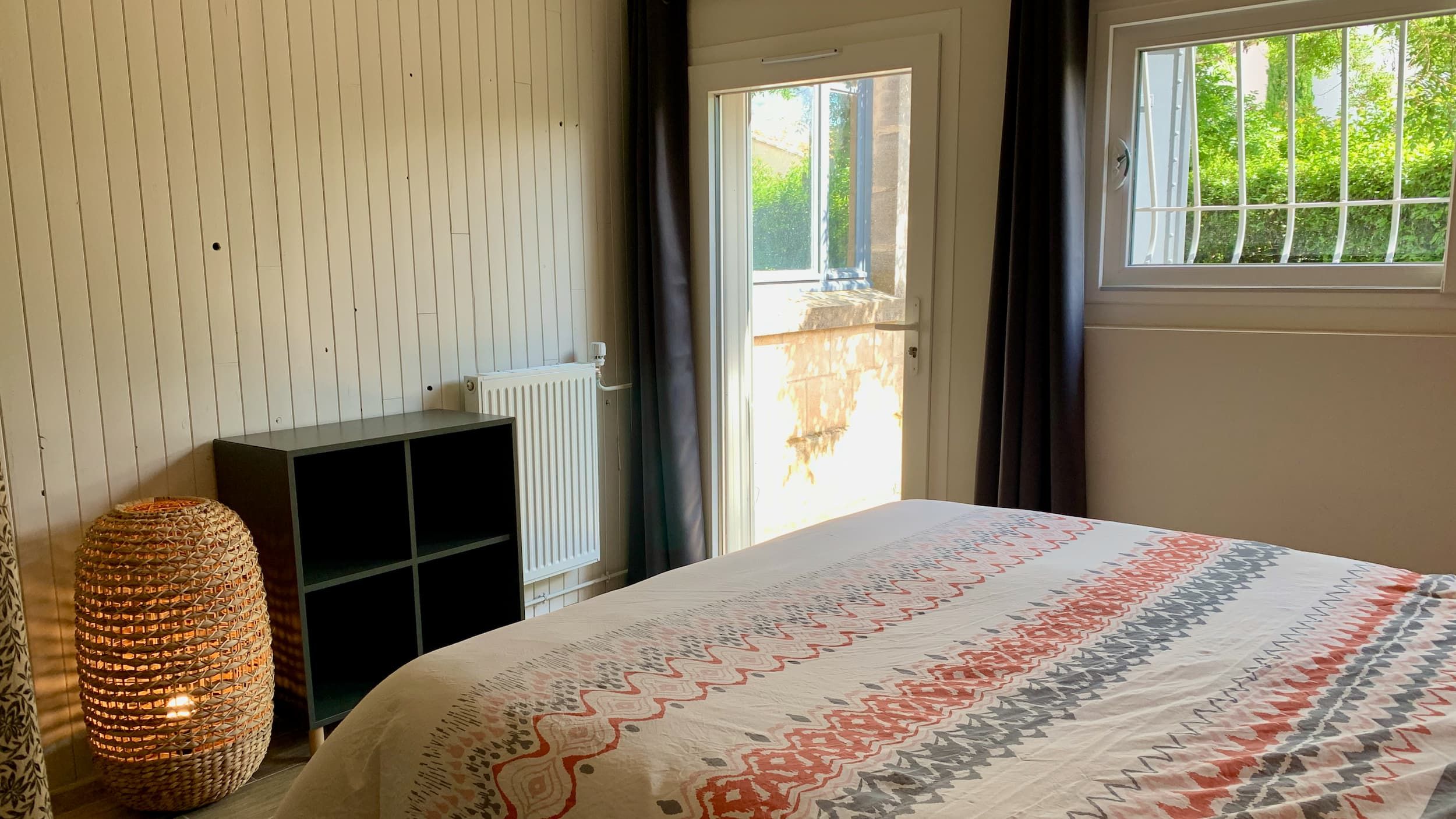 Vue de la chambre avec le lit double, le placard et la bibliothèque